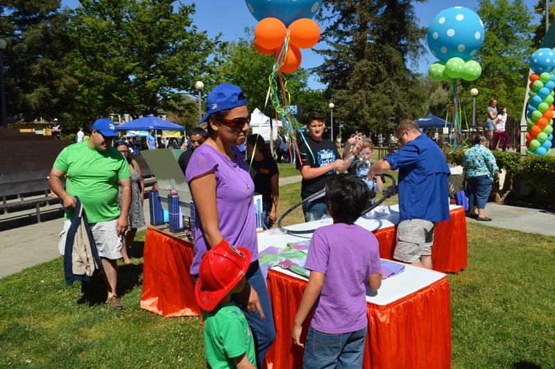 Children and Adults Learning at an Earth Day Booth